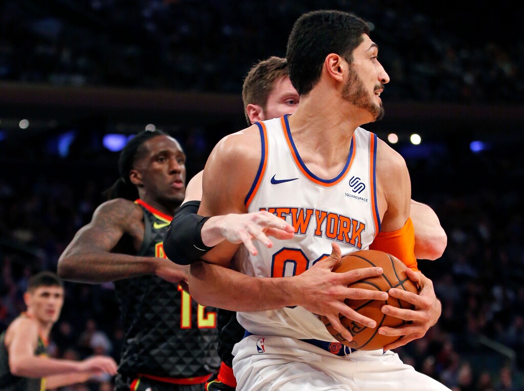 New York Knicks center Enes Kanter (00) get tangled up with Atlanta Hawks' Luke Babbitt, behind him, as Hawks forward Taurean Prince (12) watches, left, in the first half of an NBA basketball game at Madison Square Garden in New York, Sunday, Dec. 10, 2017. (AP Photo/Kathy Willens)