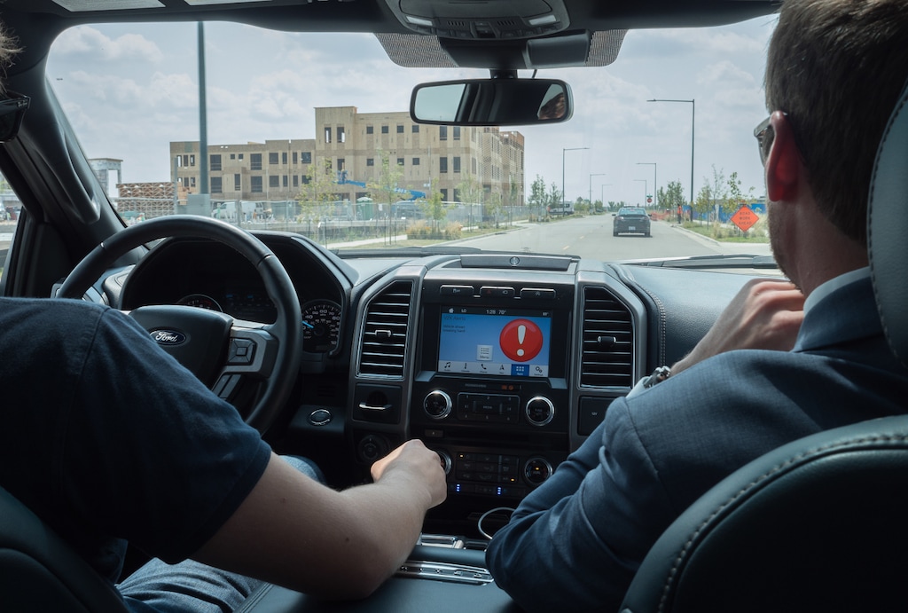 (Photo courtesy of Panasonic North America) A basic warning is shown in a car where workers experiment with a system seeking to allow cars to communicate with each other and a central system to help avoid crashes.