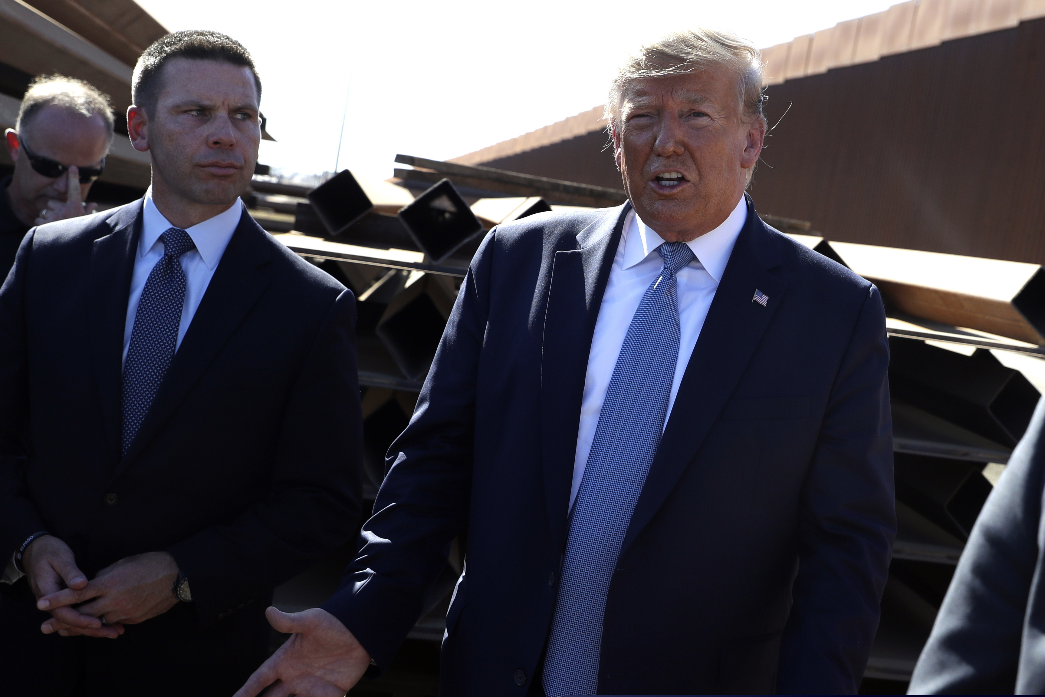 (Evan Vucci | AP) In this Sept. 18, 2019, file photo, President Donald Trump talks with reporters as he tours a section of the southern border wall, in Otay Mesa, Calif., as acting Homeland Secretary Kevin McAleenan listens. President Donald Trump announced Oct. 11, 2019, that McAleenan is stepping down.