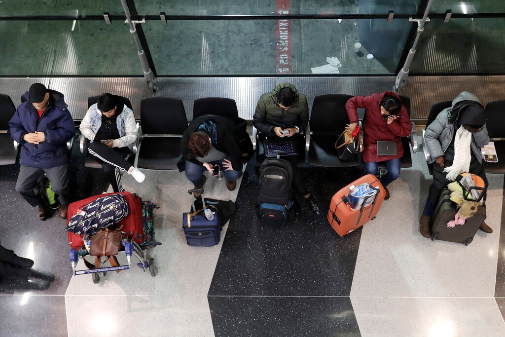 (Nam Y. Huh | AP file photo) Travelers sit as they wait for their flight at O'Hare airport in Chicago, Friday, Jan. 17, 2020.