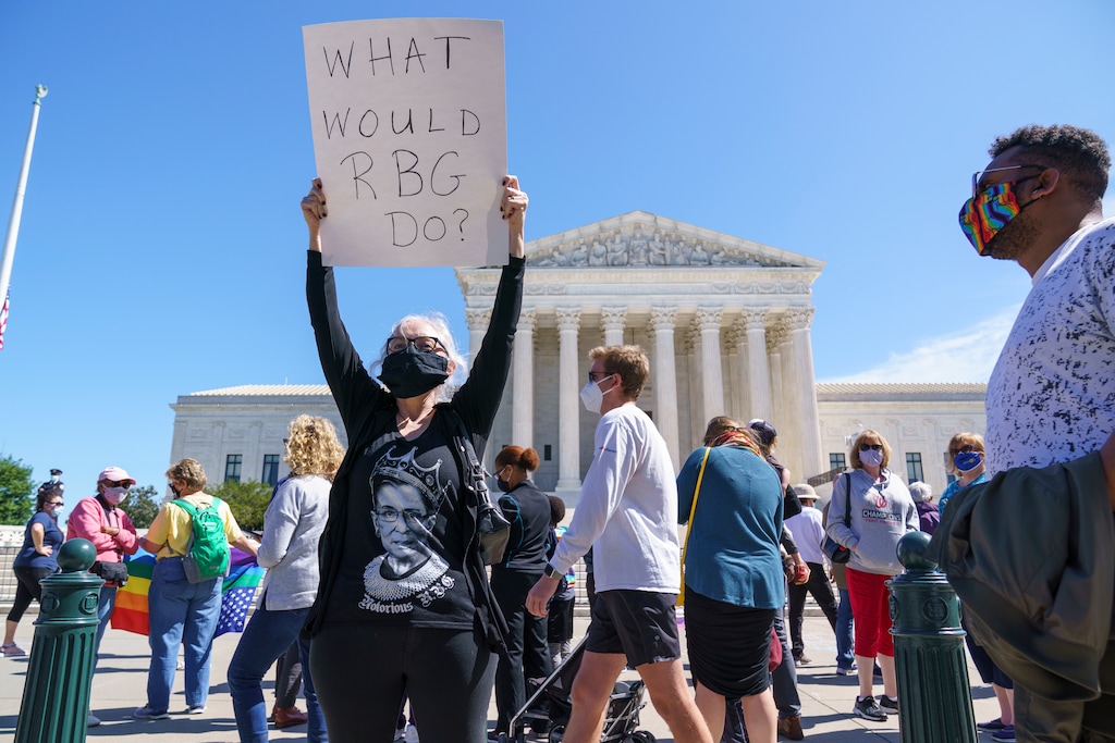 (J. Scott Applewhite | AP file photo)  Kelli Midgley, center, an English teacher from Baltimore,  joins people gathered at the Supreme Court to honor the late Justice Ruth Bader Ginsburg in Washington, Saturday, Sept. 19, 2020.