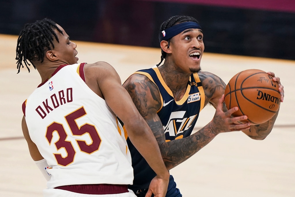 Utah Jazz's Jordan Clarkson, right, drives to the basket against Cleveland Cavaliers' Isaac Okoro during the first half of an NBA basketball game Tuesday, Jan. 12, 2021, in Cleveland. (AP Photo/Tony Dejak)
