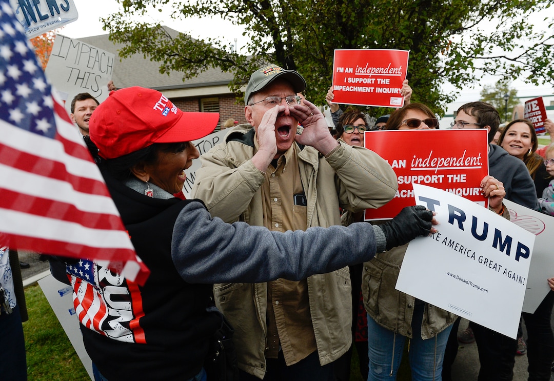 (Francisco Kjolseth | The Salt Lake Tribune) Two competing rallies spar near Rep. Ben McAdams' office in West Jordan, one seeking to support McAdams and one to criticize him for supporting the impeachment inquiry of President Donald Trump on Wednesday, Oct. 9, 2019, as they try to block one another's signs during a brief moment of confrontation.