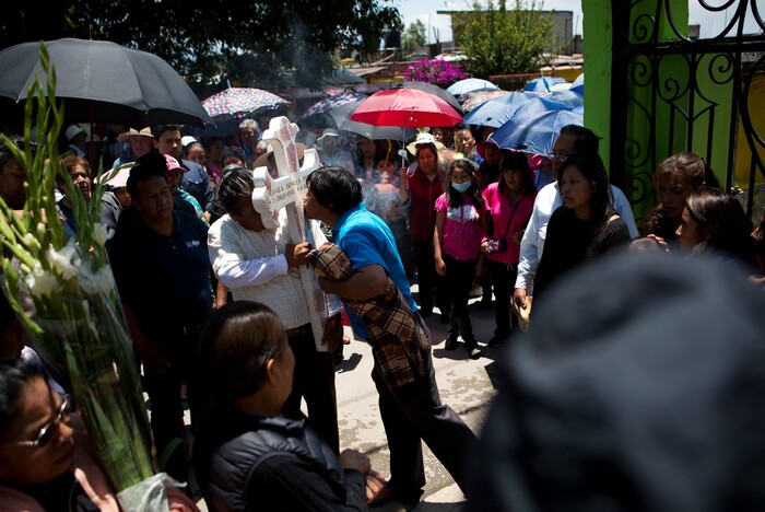 In this Aug. 18, 2017 photo, a man kisses a cross brought by family members and friends of murdered Dr. Jessica Sevilla Pedraza, 29, at the entrance to the cemetery in Villa Cuauhtemoc, Mexico state. Jessica's gruesome murder remains unsolved. (AP Photo/Rebecca Blackwell)