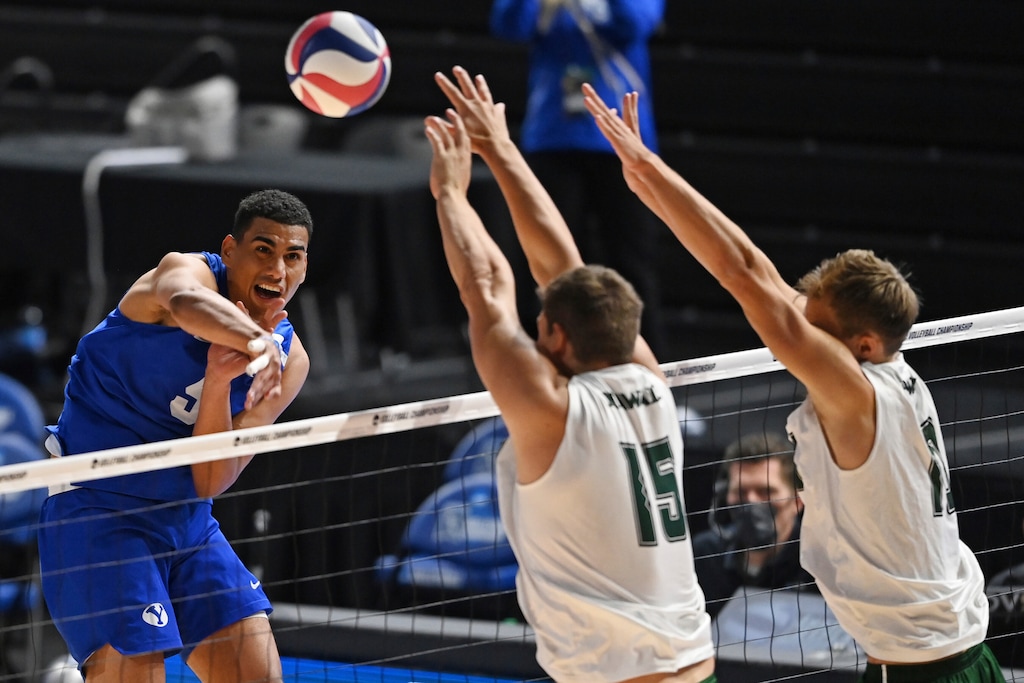 (David Dermer | AP) BYU's Gabi Garcia Fernandez (5) hits the ball as Hawaii's Patrick Gasman (15) and Jakob Thelle (10) go for a block during the NCAA men's volleyball championship match Saturday, May 8, 2021, in Columbus, Ohio. Hawaii swept BYU to win the title.