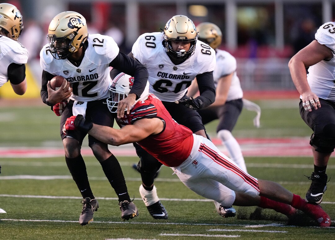 (Francisco Kjolseth | The Salt Lake Tribune) Colorado Buffaloes quarterback Brendon Lewis (12) is taken down  by Utah Utes defensive end Van Fillinger (7) as the University of Utah hosts the Colorado Buffaloes in Pac-12 football, Friday, Nov. 26, 2021 at Rice-Eccles Stadium.