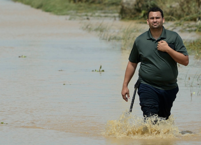 A resident walks on a flooded road after the passing of Hurricane Maria, in Toa Baja, Puerto Rico, Friday, September 22, 2017. Because of the heavy rains brought by Maria, thousands of people were evacuated from Toa Baja after the municipal government opened the gates of the Rio La Plata Dam. (AP Photo/Carlos Giusti)