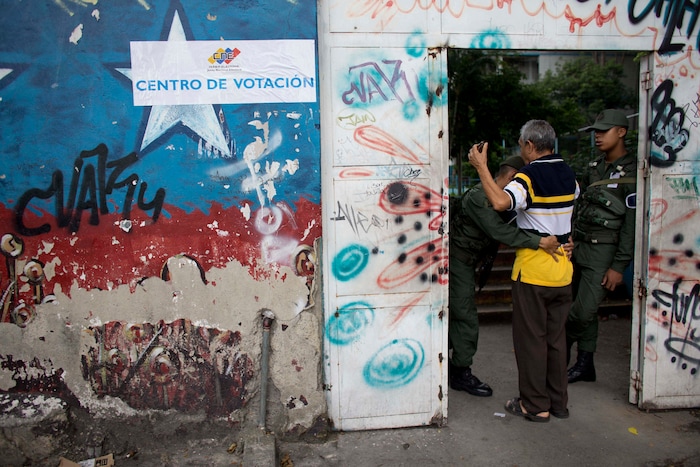 A National Guard soldier frisks a man before allowing him inside a polling station during regional elections in Caracas, Venezuela, Sunday, Oct. 15, 2017. Elections could tilt a majority of the states’ 23 governorships back into opposition control for the first time in nearly two decades of socialist party rule, though the government says the newly elected governors will be subordinate to a pro-government assembly. (AP Photo/Ariana Cubillos)