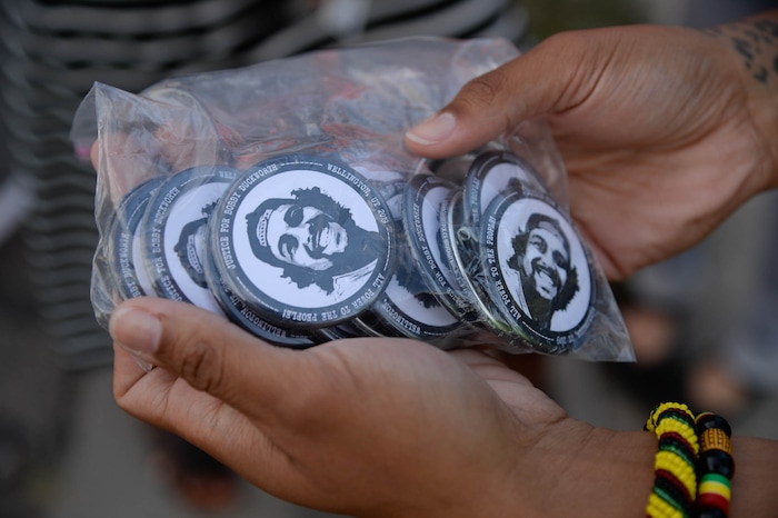 (Francisco Kjolseth  |  The Salt Lake Tribune) Rae Duckworth holds some of the pins made in honor of her cousin Bobby Duckworth who was killed by police as people gather for a vigil on the six-year anniversary of Dillon Taylor’s death by the murals of those people killed by police near 800 South and 300 West in Salt Lake City on Tuesday, August 11, 2020. Multiple families who’s loved one’s are depicted on the walls joined the vigil as they moved from portrait to portrait to remember them.