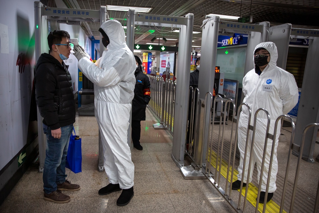(Mark Schiefelbein | AP) A worker wearing a hazardous materials suit takes the temperature of a passenger at the entrance to a subway station in Beijing, Sunday, Jan. 26, 2020. The new virus accelerated its spread in China, and the U.S. Consulate in the epicenter of the outbreak, the central city of Wuhan, announced Sunday it will evacuate its personnel and some private citizens aboard a charter flight.