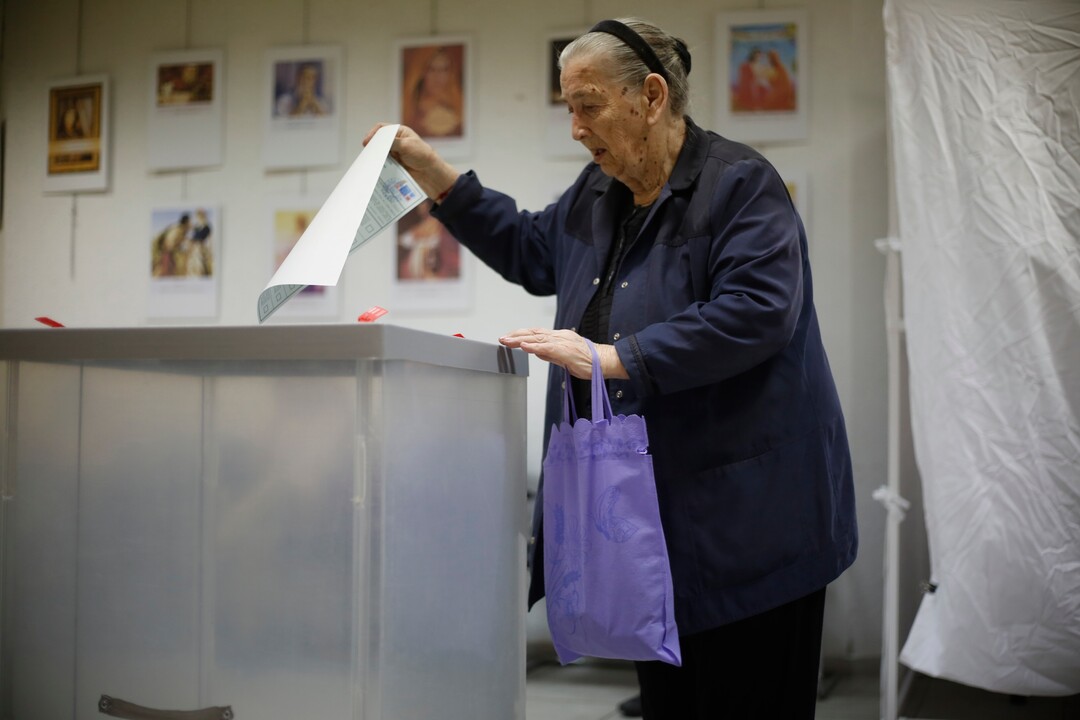 A Russian woman is abut to cast her ballot for the presidential election in Netanya, Israel, Sunday, March 18, 2018. Russians in Israel are voting in a presidential election in which Vladimir Putin is seeking a fourth term in the Kremlin. (AP Photo/Ariel Schalit)
