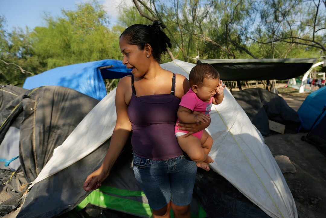 In this Tuesday, Nov. 5, 2019, photo, migrant Justina holds her daughter, Samantha, at a refugee camp where she lives in Matamoros, Mexico. Shortly after they entered the U.S. to seek asylum in September, Justina and Samantha were taken to a type of Border Patrol station that migrants refer to as the “hielera,” or icebox. Samantha started having a fever and a cough. Eventually, her illness developed into pneumonia. (AP Photo/Eric Gay)
