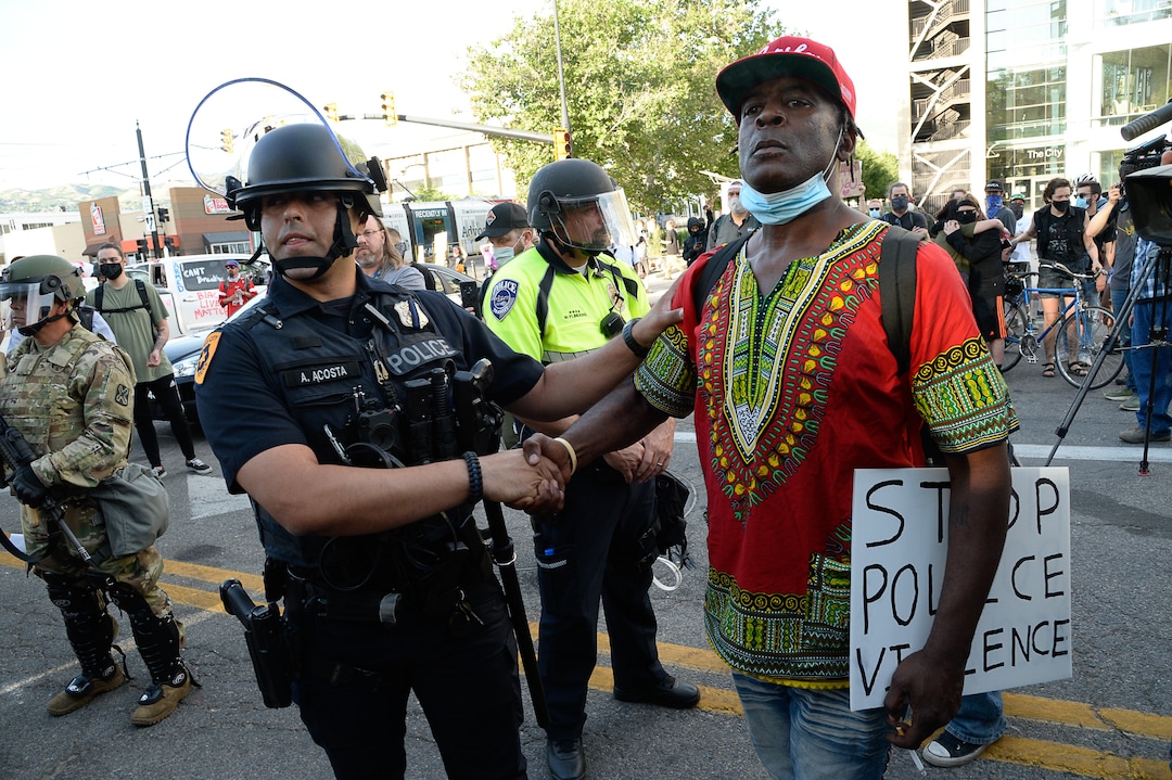 (Francisco Kjolseth  |  The Salt Lake Tribune) Officer M. Acosta shakes hands with Hasson Davis as demonstrators protest against police brutality on Tuesday, June 2, 2020, in downtown Salt Lake City, as an 8 p.m. weeklong curfew remains in order.