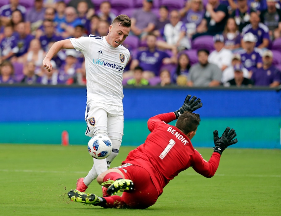 Real Salt Lake's Corey Baird, left, scores a goal as he kicks the ball past Orlando City goalkeeper Joseph Bendik (1) during the first half of an MLS soccer match, Sunday, May 6, 2018, in Orlando, Fla. (AP Photo/John Raoux)