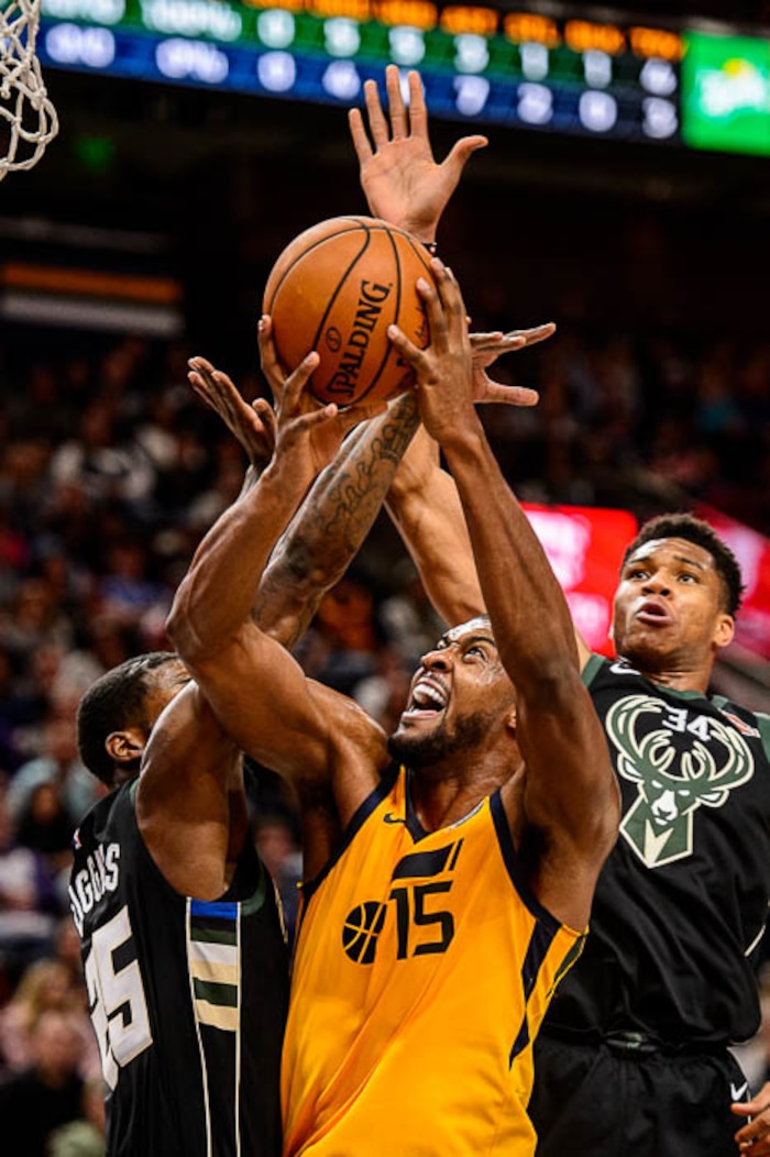 (Trent Nelson | The Salt Lake Tribune)  Utah Jazz forward Derrick Favors (15) shoots as the Utah Jazz host the Milwaukee Bucks, NBA basketball in Salt Lake City Saturday November 25, 2017. Defending are Milwaukee Bucks guard DeAndre Liggins (25) and Milwaukee Bucks forward Giannis Antetokounmpo (34).
