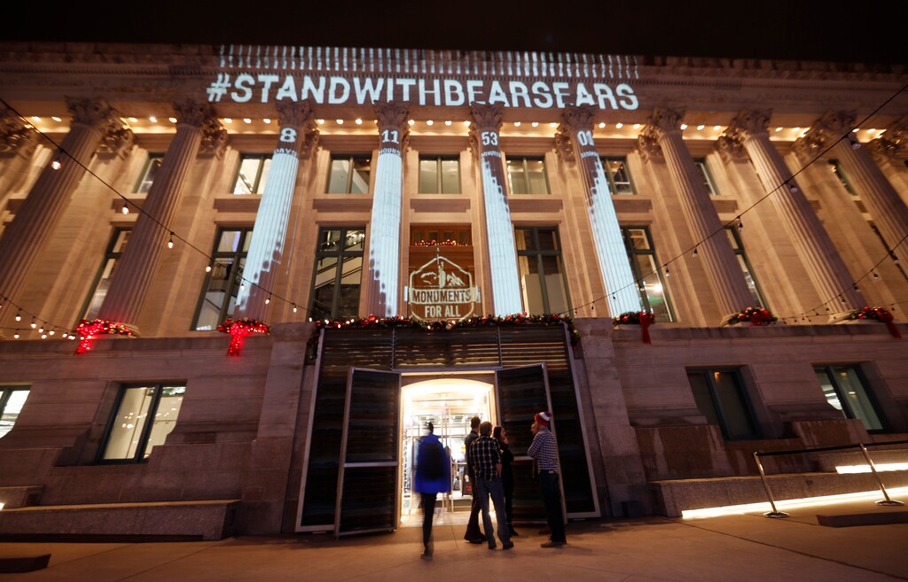 A countdown clock is projected on the side of the McNichols Civic Center building as guests arrive at a welcome party to mark the opening of the Outdoor Retailer and Snow Show Wednesday, Jan. 24, 2018, in downtown Denver. The show, which is the largest gathering in the United States for the $887 billion outdoor and winter sports industries, is making its Denver debut after leaving Salt Lake City, Utah. A group of outdoor industry leaders and conservation organizations projected the countdown clock in protest of President Donald Trump's recent removal of vast portions of Bears Ears and Grand Staircase Escalante national monuments in Utah, the largest ever elimination of protected areas in the history of the United States. (AP Photo/David Zalubowski)
