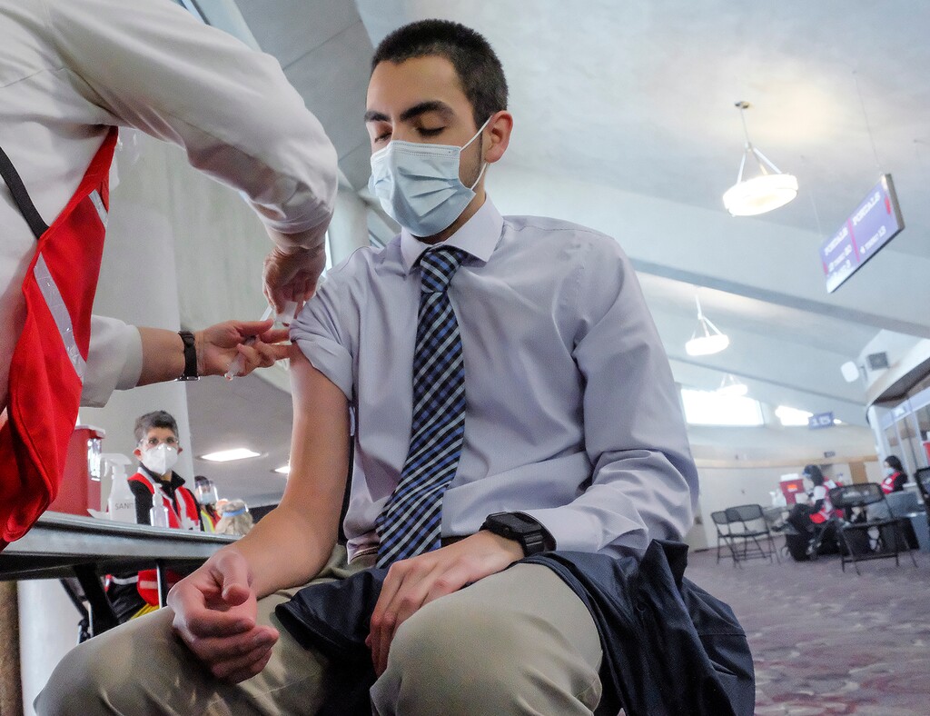 (Leah Hogsten  |  The Salt Lake Tribune) Matt Mendoza, a scribe for a doctor's office, receives the COVID-19 vaccine on Tuesday. The Weber-Morgan Health Department began distributing the COVID-19 vaccine to health care workers in non-hospital settings at Weber State University's Dee Events Center, Jan. 5, 2020. The health department hopes to vaccinate 1,000 a day.  