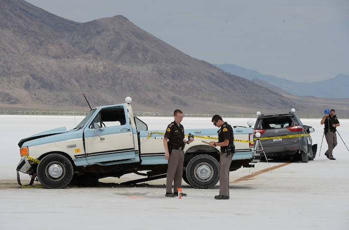 (Francisco Kjolseth | The Salt Lake Tribune) Highway patrol investigate the scene of a deadly crash at Utah's Bonneville Salt Flats along the sidelines of Speed Week following a head-on collision between two vehicles carrying support crew traveling between the pits and the entrance to the salt along the access road on Wednesday, Aug. 16, 2017. One person was killed and five injured, all of whom were said to be members of support crews for racing drivers.