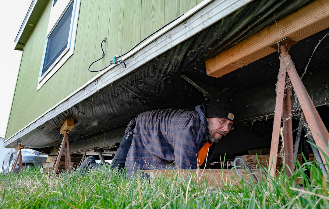 (Francisco Kjolseth  |  The Salt Lake Tribune) Antonio Tunno risks going under his home in the Western Estates mobile home park in Magna on Monday, March 23, 2020, for the first time since last week's earthquake despite feeling an aftershock earlier in the morning. Using wood blocks, Tunno was trying to shore up his home after multiple jacks under his home had failed, much like many of his surrounding neighbors.