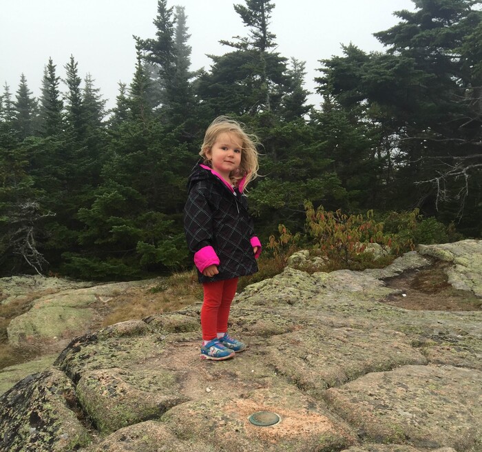 (Mary Demorest | Courtesy image) The author's daughter perches atop Cadillac Mountain, the highest point in Acadia National Park, on Sept. 29, 2015.