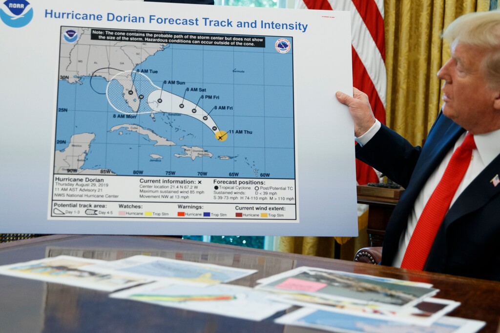 President Donald Trump holds a chart as he talks with reporters after receiving a briefing on Hurricane Dorian in the Oval Office of the White House, Wednesday, Sept. 4, 2019, in Washington. (AP Photo/Evan Vucci)