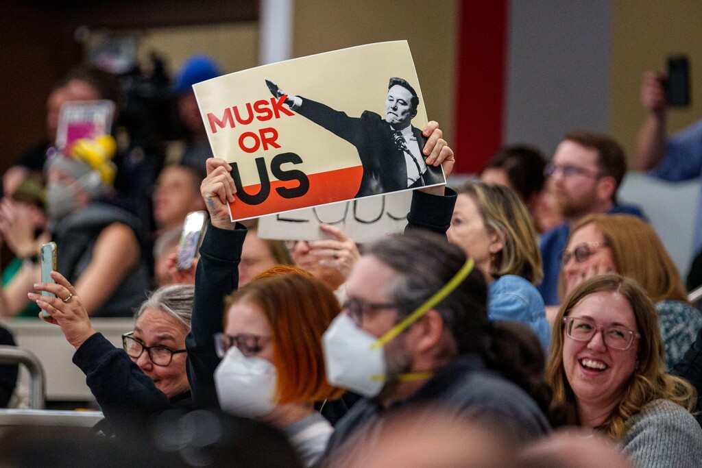 (Trent Nelson | The Salt Lake Tribune) 
Audience members hold signs at a joint town hall with U.S. Reps. Celeste Maloy and Mike Kennedy in Salt Lake City on Thursday, March 20, 2025.