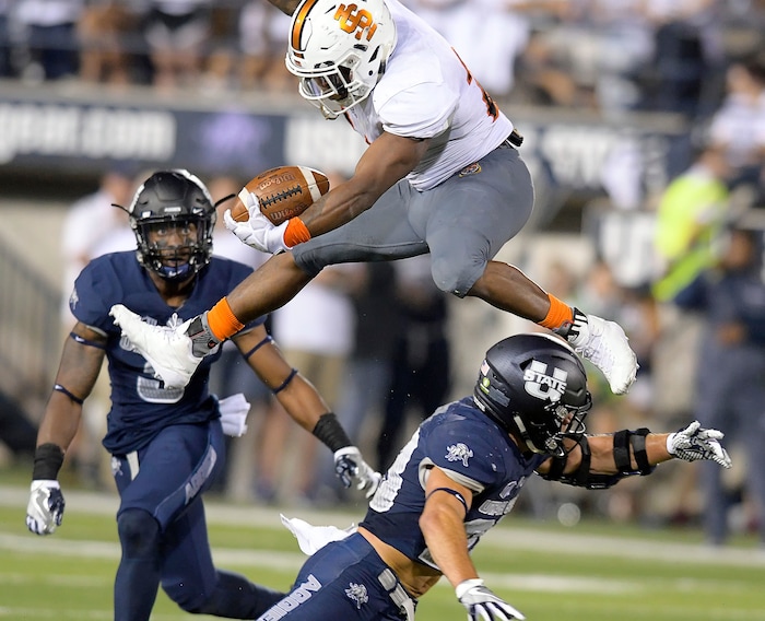 Idaho State running back Ty Flanagan leaps over Utah State safety Gaje Ferguson during an NCAA college football game Thursday, Sept. 7, 2017, in Logan, Utah. (Eli Lucero/Herald Journal via AP)