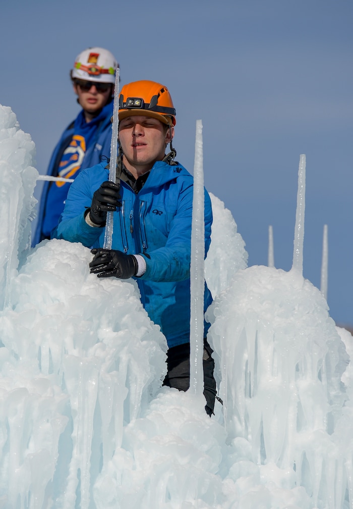 Leah Hogsten | The Salt Lake Tribune l-r Jacob Livingston and Coby Thacker place icicles on top of the Ice Castle to make higher walls for the structure. The idea started with a backyard castle in Alpine followed by an ice castle in downtown Midway in 2009. Ice Castles is open for the winter Saturday, Jan. 5, at Homestead Resort. This is the ninth season the popular frozen art installation is drawing visitors to walk around the giant LED-lit icicle formations.