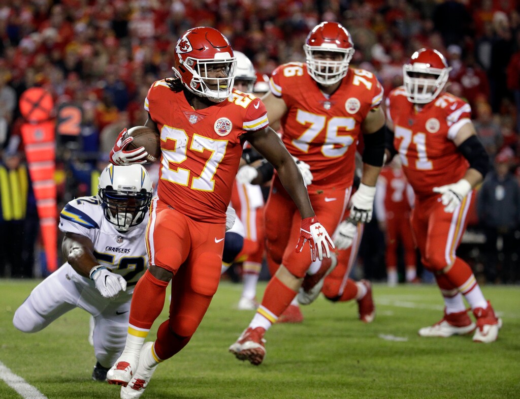 Kansas City Chiefs running back Kareem Hunt (27) runs past a tackle attempt by Los Angeles Chargers linebacker Denzel Perryman (52) during the first half of an NFL football game in Kansas City, Mo., Saturday, Dec. 16, 2017. (AP Photo/Charlie Riedel)
