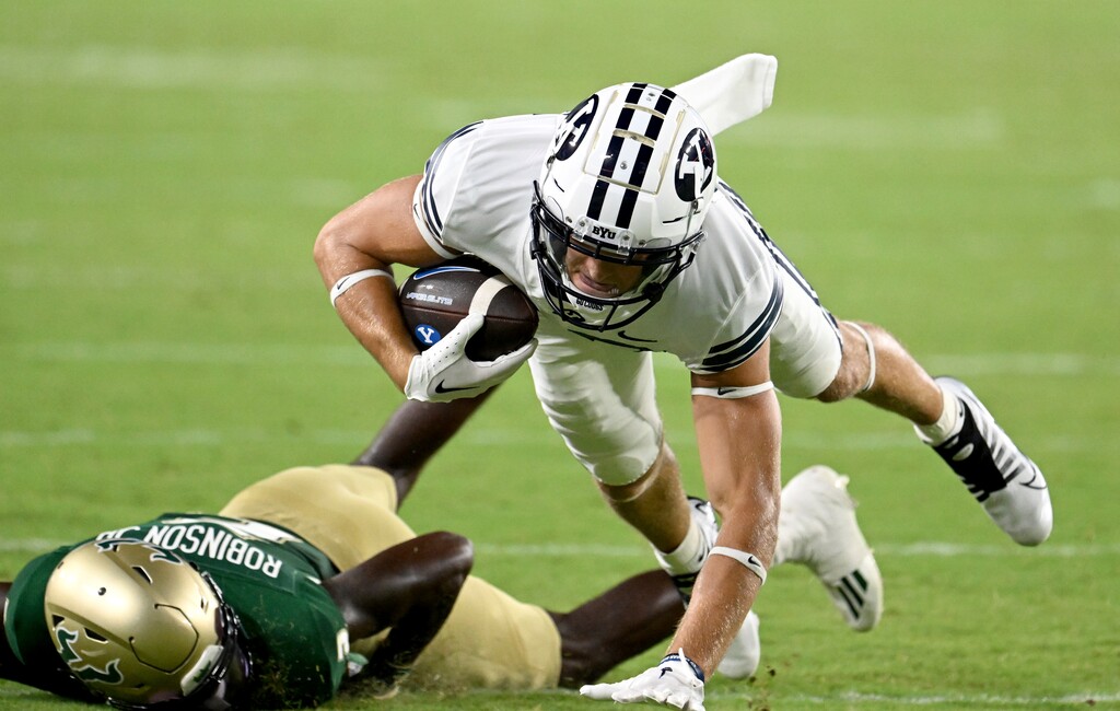 (Jason Behnken | AP) BYU wide receiver Chase Roberts, top, is brought down by South Florida defensive back TJ Robinson, bottom, during the second half of an NCAA college football game Saturday, Sept. 3, 2022, in Tampa, Fla.