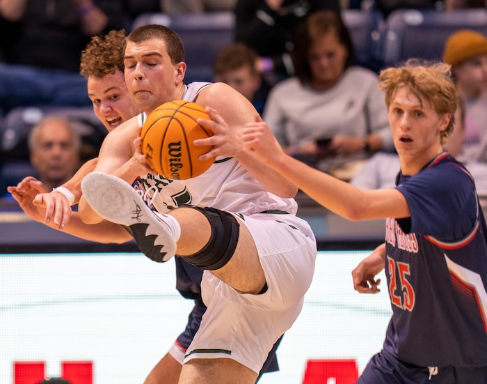 (Rick Egan | The Salt Lake Tribune) 
Olympus Titan, center, Jack Wistrcill (15) grabs a pass, as Woods Cross forward Nic Hogan (34) and Alex Brey (25) defend, in the 5A State Championship game between Woods Cross and Olympus, at the Marriott Center in Provo, on Saturday, March 5, 2022. 