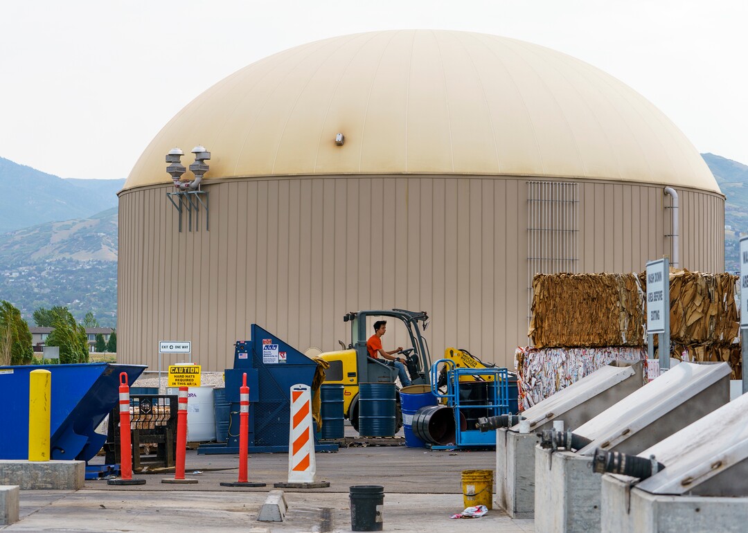 (Leah Hogsten | The Salt Lake Tribune) Wasatch Resource Recovery employee Peter Ivie drives a forklift past the digester full of organic waste that is fed enzymes and heated to aid the growth of microbes. The microbes break down in the organic matter, turning the slurry into biogas production, Sept. 1, 2021. Wasatch Resource Recovery is UtahÕs first and only anaerobic digester which produces a fertilizer and natural gas from decomposing food. The facility processes organic waste which includes food scraps, liquid waste and manufacturing food waste. The process, in operation since 2019, turns the organic matter into sustainable resources, biogas and bio-based fertilizer and the facility will pilot a food scraps pickup program for residents.