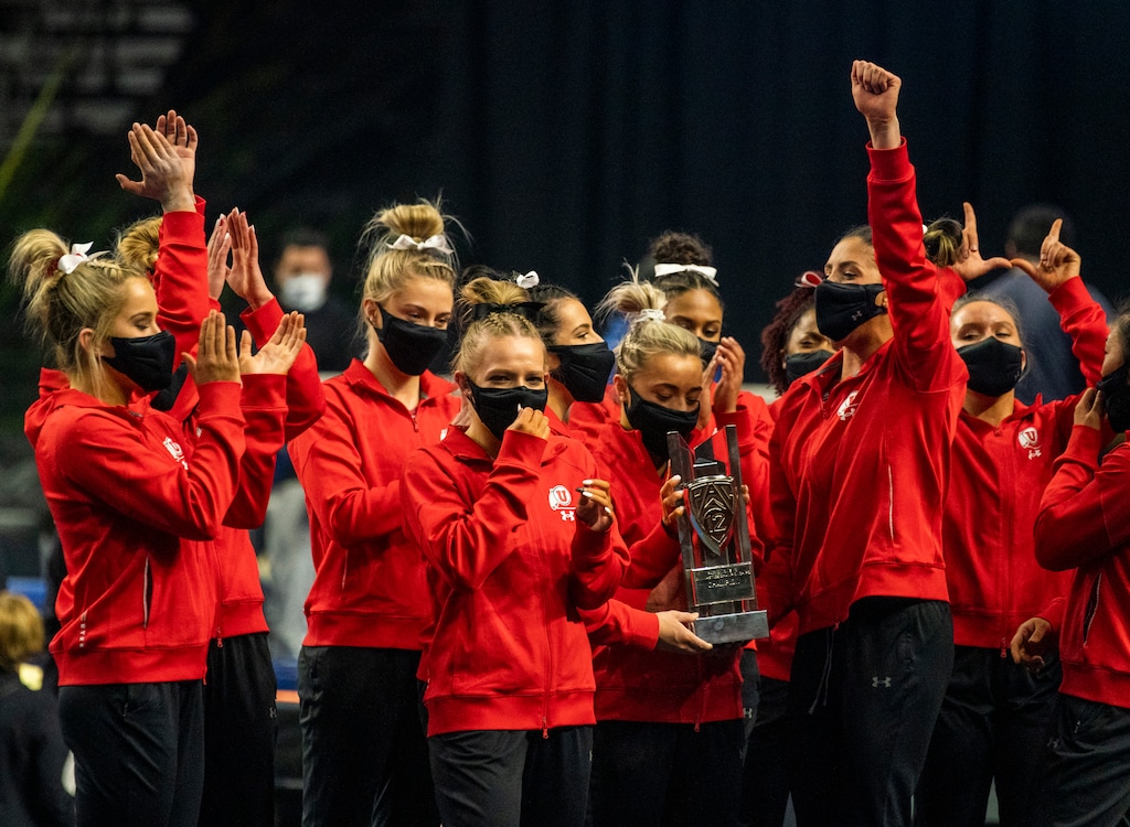 (Rick Egan | The Salt Lake Tribune) Utah celebrates with the Pac-12 Gymnastics Championship trophy at the Maverik Center on Saturday, March 20, 2021.