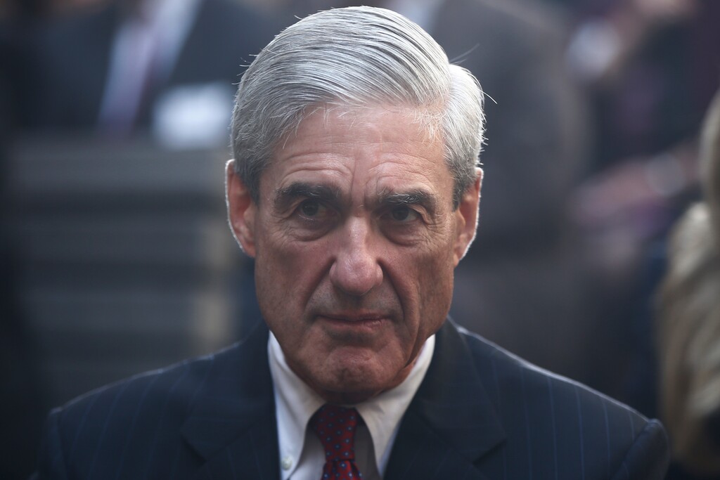 In this Oct. 28, 2013, file photo, former FBI Director Robert Mueller is seated before President Barack Obama and FBI Director James Comey arrive at an installation ceremony at FBI Headquarters in Washington. A Washington restaurant announced on Nov. 1, 2017, it is offering a special $5 “Moscow Mueller” drink every time Mueller, who is now special counsel for the Department of Justice, indicts an associate of President Donald Trump. (AP Photo/Charles Dharapak, File)