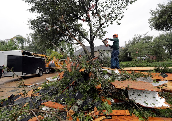 (David J. Phillip | The Associated Press) Henry Isaac cuts down broken tree limbs after  Hurricane Harvey Saturday, Aug. 26, 2017, in Missouri City, Texas.  Harvey rolled over the Texas Gulf Coast on Saturday, smashing homes and businesses and lashing the shore with wind and rain so intense that drivers were forced off the road because they could not see in front of them.