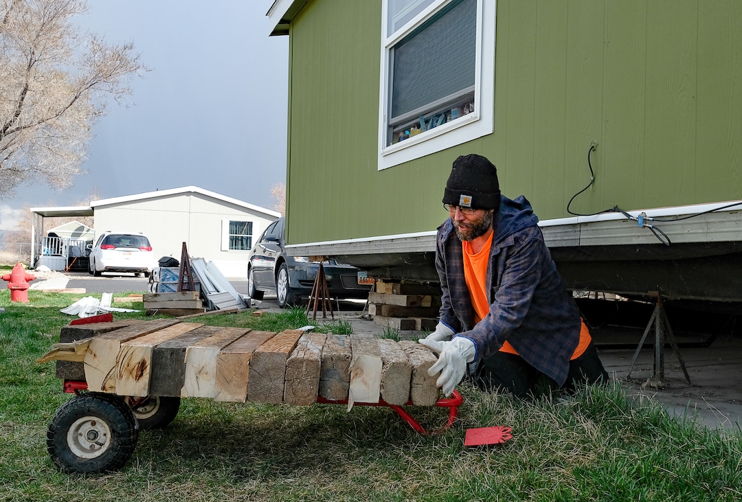 (Francisco Kjolseth  |  The Salt Lake Tribune) Antonio Tunno risks going under his home in the Western Estates mobile home park in Magna on Monday, March 23, 2020, for the first time since last week's earthquake despite feeling an aftershock earlier in the morning. Using wood blocks, Tunno was trying to shore up his home after multiple jacks under his home had failed, much like many of his surrounding neighbors.
