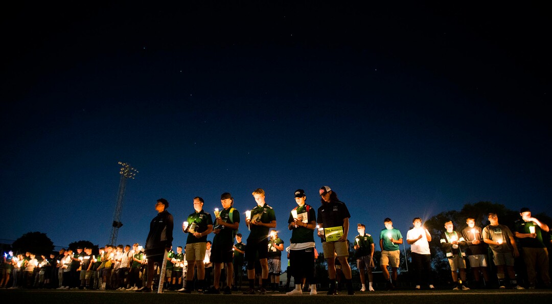 (Rick Egan  |  The Salt Lake Tribune)THe Hillcrest football team lines up on the 50-yard line during a candlelight vigil in honor of coach Cazzie Brown, at Hillcrest High School, Monday, August 28, 2017.