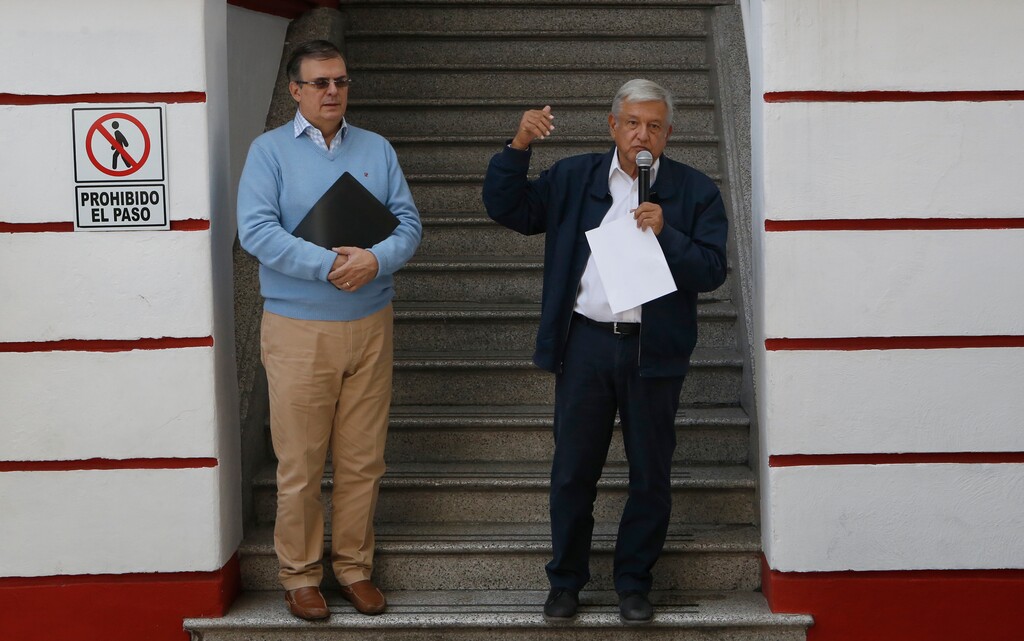 Mexico's President-elect Andres Manuel Lopez Obrador, right, and his future Foreign Minister, Marcelo Ebrard, speaks to the press outside his party's headquarters in Mexico City, Sunday, July 22, 2018. Lopez Obrador has released a seven-page letter he sent to U.S. President Donald Trump earlier in July detailing how he sees the two countries working together to stem immigration. (AP Photo/Marco Ugarte)