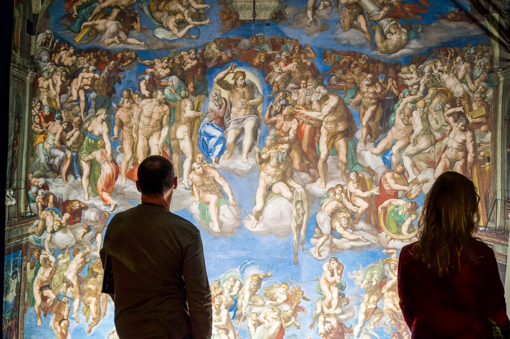 (Palak Jayswal | The Salt Lake Tribune) Exhibit visitors look at the details of “The Last Judgment,” part of the traveling "Michelangelo at the Sistine Chapel: The Exhibition," seen here on April 28, 2022. The exhibition will be on display at The Gateway in downtown Salt Lake City, from April 29 to June 19, 2022.