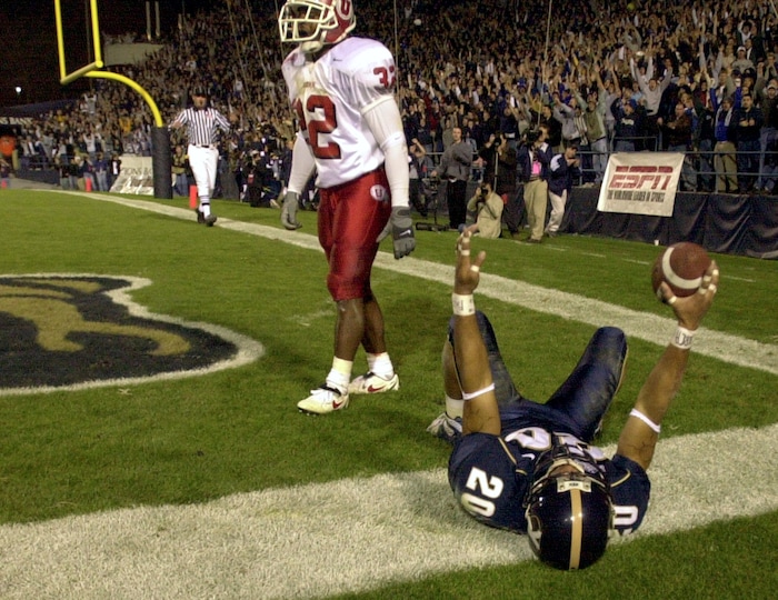 (Rick Egan  |  Tribune File Photo)  BYU's Reno Mahe celebrates BYU's first touchdown as Ute defender D'Dhaun Crockett stands in the end zone on November 17, 2001.