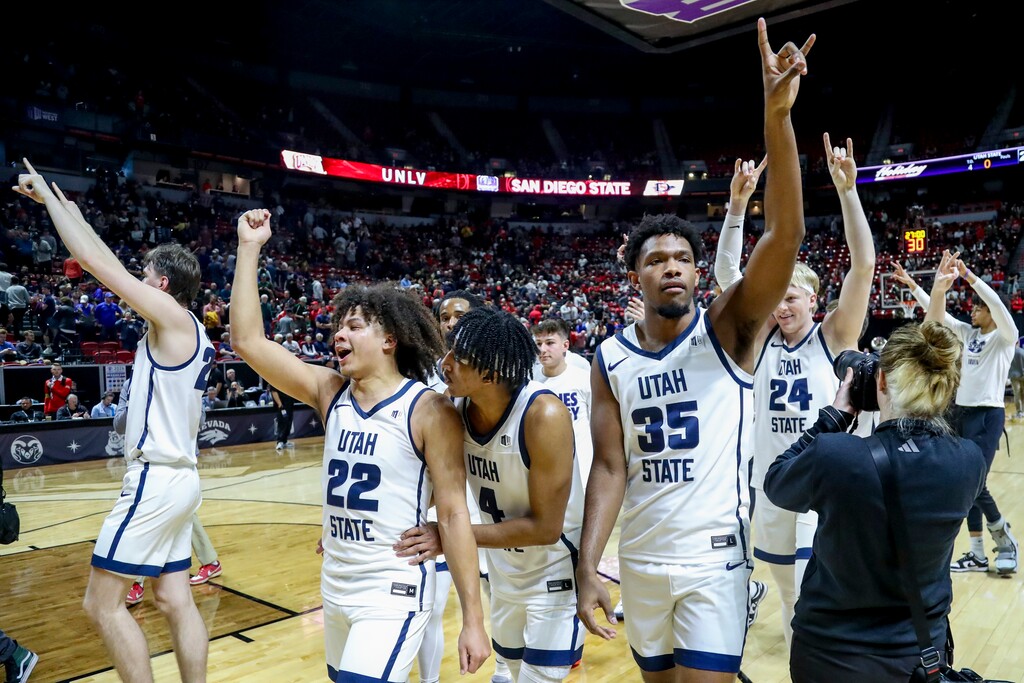 Utah State's Javon Jackson (22), Ian Martinez (4), and Nigel Burris (35) celebrate after defeating Fresno State in an NCAA college basketball game in the quarterfinal round of the Mountain West Conference tournament, Thursday, March 14, 2024, in Las Vegas. (AP Photo/Ian Maule)