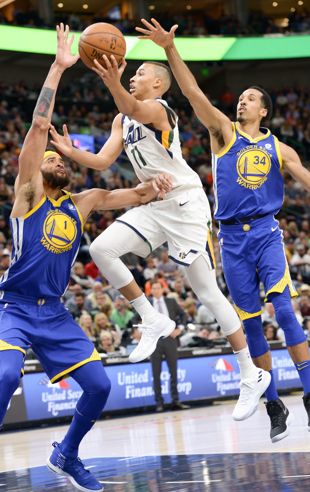 (Leah Hogsten  |  The Salt Lake Tribune)   Utah Jazz guard Dante Exum (11) slips past Golden State Warriors center JaVale McGee (1) and Golden State Warriors guard Shaun Livingston (34). The Utah Jazz lead the Golden State Warriors 62-33 during their game, Tuesday, April 10, 2018 at the Vivant Smart Home Arena. 