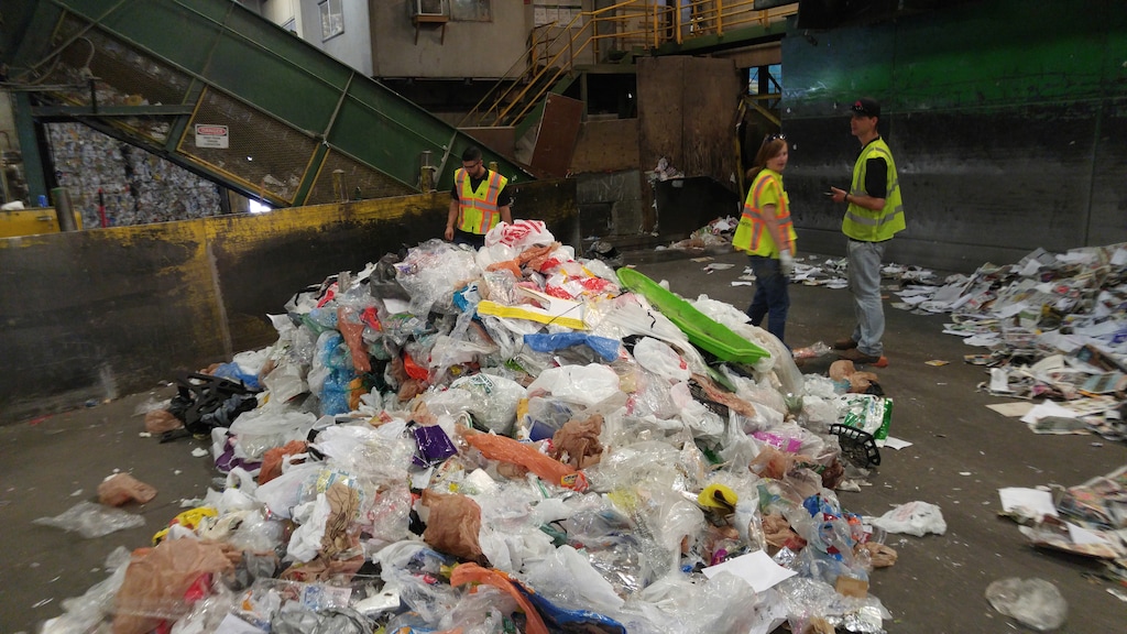 Recycling workers at one of Salt Lake City's processing facilities last fall look over a mountain of plastic bags and other items removed from regular curb-side recycling pick-up because they are not recyclable. The city is now asking residents not to put plastic bags or wrap in their blue recycling bins.