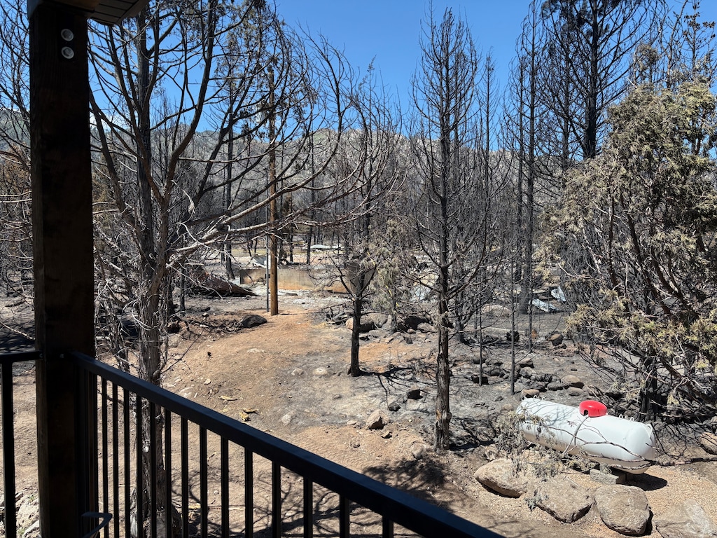 A photo from the Kelsches' deck with burnt trees in the background and a wide wooden post on the corner of the deck in the foreground.