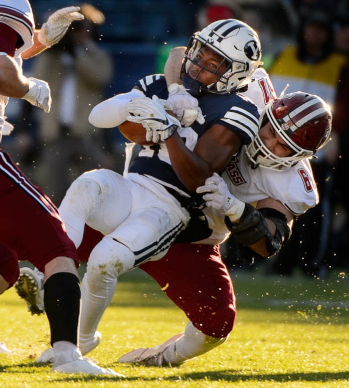 (Trent Nelson | The Salt Lake Tribune)  Brigham Young Cougars defensive back Michael Shelton (18) is tackled by Massachusetts Minutemen defensive lineman Joe Previte (61) as BYU hosts the University of Massachusetts, NCAA football in Provo, Saturday November 18, 2017.