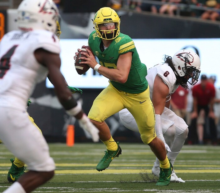 Oregon quarterback Justin Herbert, center, scrambles out of the pocket under pressure from Southern Utah's Tyler Pili, right, during the first quarter of an NCAA college football game Saturday, Sept. 2, 2017, in Eugene, Ore. (AP Photo/Chris Pietsch)