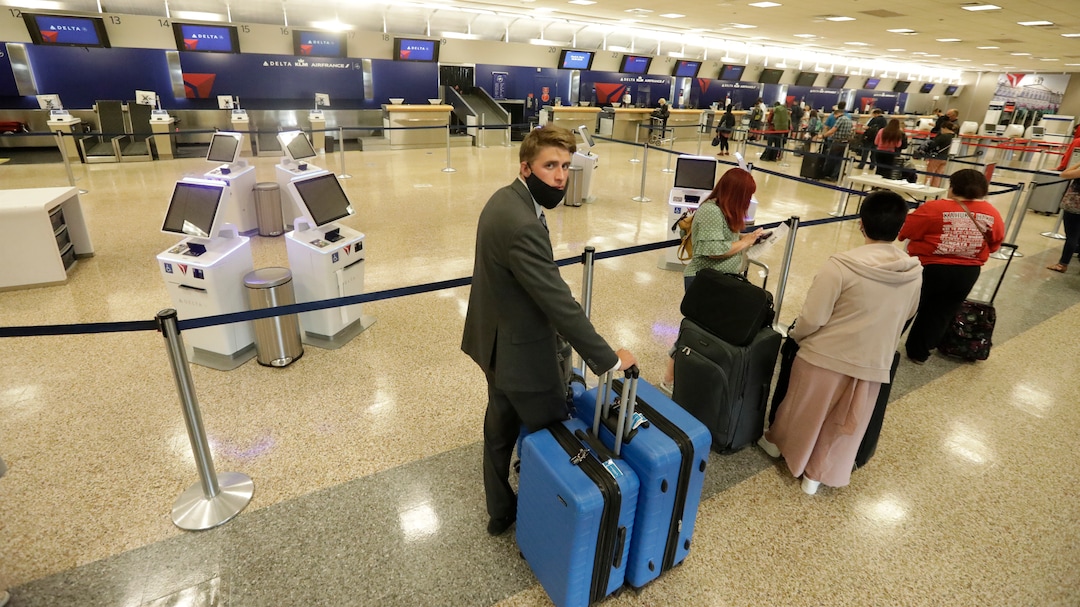 In this May 27, 2020, photo, Logan Morrison, 18, a missionary from The Church of Jesus Christ of Latter-day Saints, waits in line to get to ticket counter, at Salt Lake City International Airport, before leaving on his mission to St. Louis. After hastily bringing home 26,000 young men and women who were serving in foreign countries, the faith has begun sending many of them out again in their home countries with a new focus on online work that could stick even when the pandemic is over, church officials told The Associated Press. (AP Photo/Rick Bowmer)