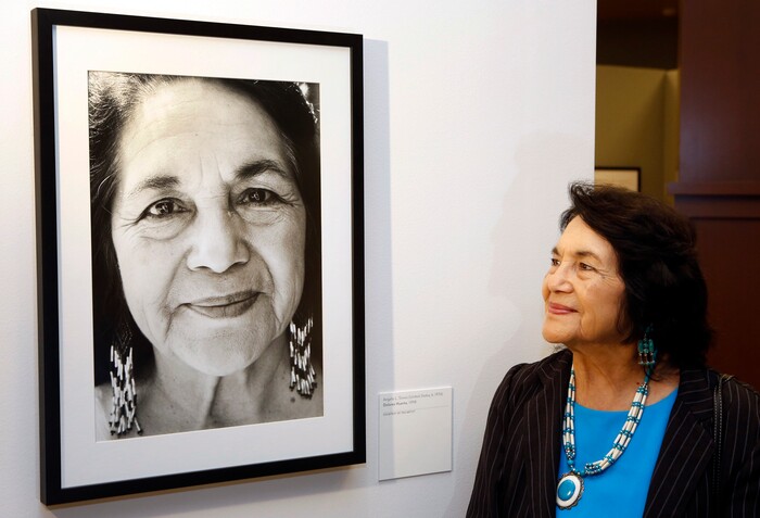 FILE - In this April 10, 2014, file photo, Dolores Huerta, co-founder of United Farms Workers stands by a portrait of herself taken in 1998 by photographer Angela Torres, as she tours her exhibition, "Viva la Causa! Dolores Huerta and the Struggle for Justice," at La Plaza de la Cultura y Artes museum downtown Los Angeles. Huerta, the social activist who formed a farm workers union with César Chávez and whose "Si, Se Puede" chant inspired Barack Obama's 2008 presidential campaign slogan, is the subject of a new PBS documentary. The film "Dolores" examines the life of the New Mexico-born Mexican-American reformer from her time as a tireless United Farm Workers leader and a campaign volunteer for Sen. Robert Kennedy's 1968 presidential run. (AP Photo/Damian Dovarganes, File)