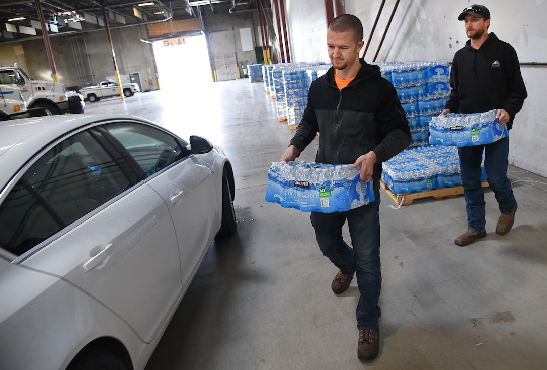 (Francisco Kjolseth  |  The Salt Lake Tribune)  Elliott Purser, center, and Cody Hook with Sandy City load up cases of water into the trunk of a resident at the Sandy Operations Center at 9150 South, 150 East on Sunday, Feb. 17, 2019. The no drink order now applies only to homes and businesses between 1700 East and 2000 East and 10600 South and 11400 South, the city announced Sunday. The city says the problem started about Feb. 6, when a fluoride pump malfunctioned because of a power outage. It flooded the water system with fluoride and that also led to high levels of lead and copper, enough that it made some people sick.