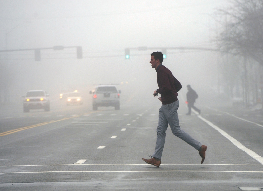 (Al Hartmann  |  Tribune file photo)
Commuters and pedestrians move through the dense fog with slippery roads along 200 South in Salt Lake City.